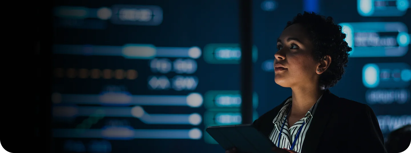 Young Multiethnic Female Government Employee Uses Tablet Computer in System Control Monitoring Center