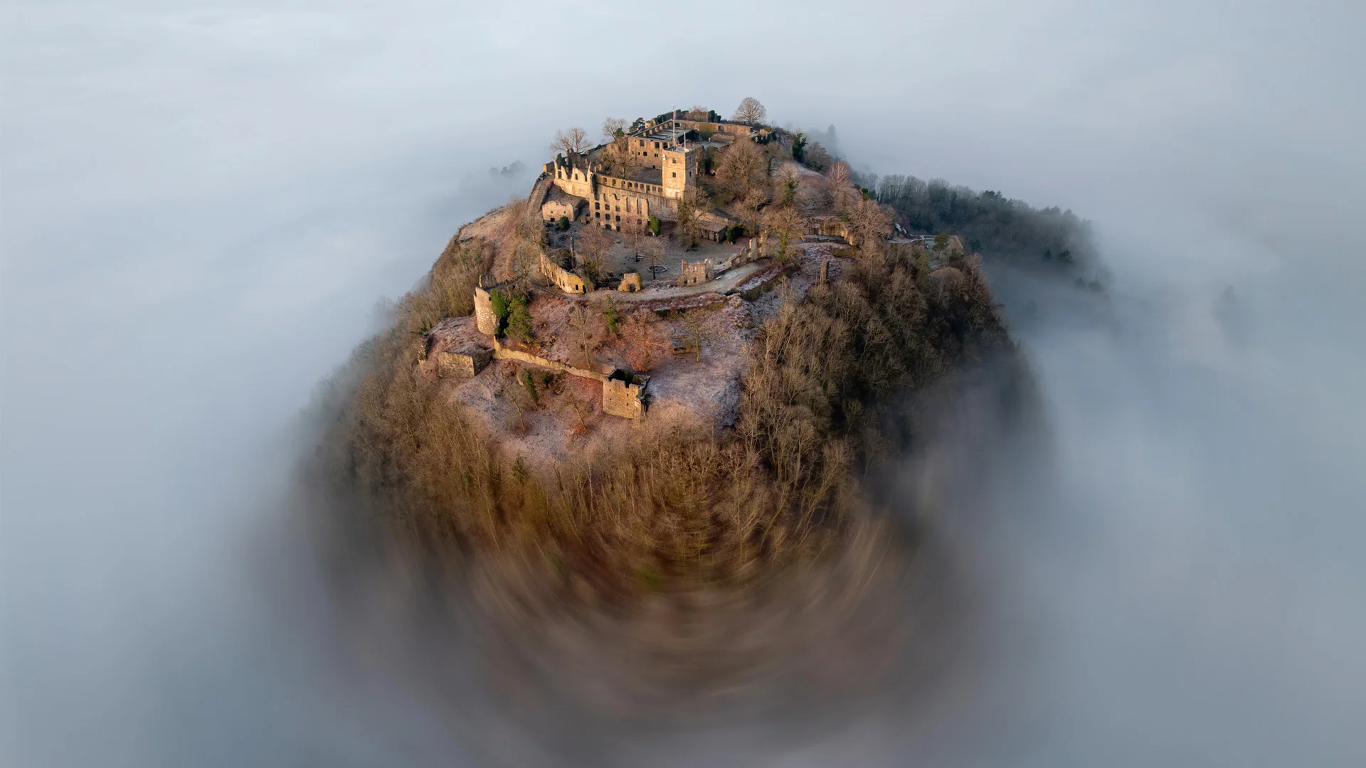 Fortress on top of a mountain, peaking through the fog.